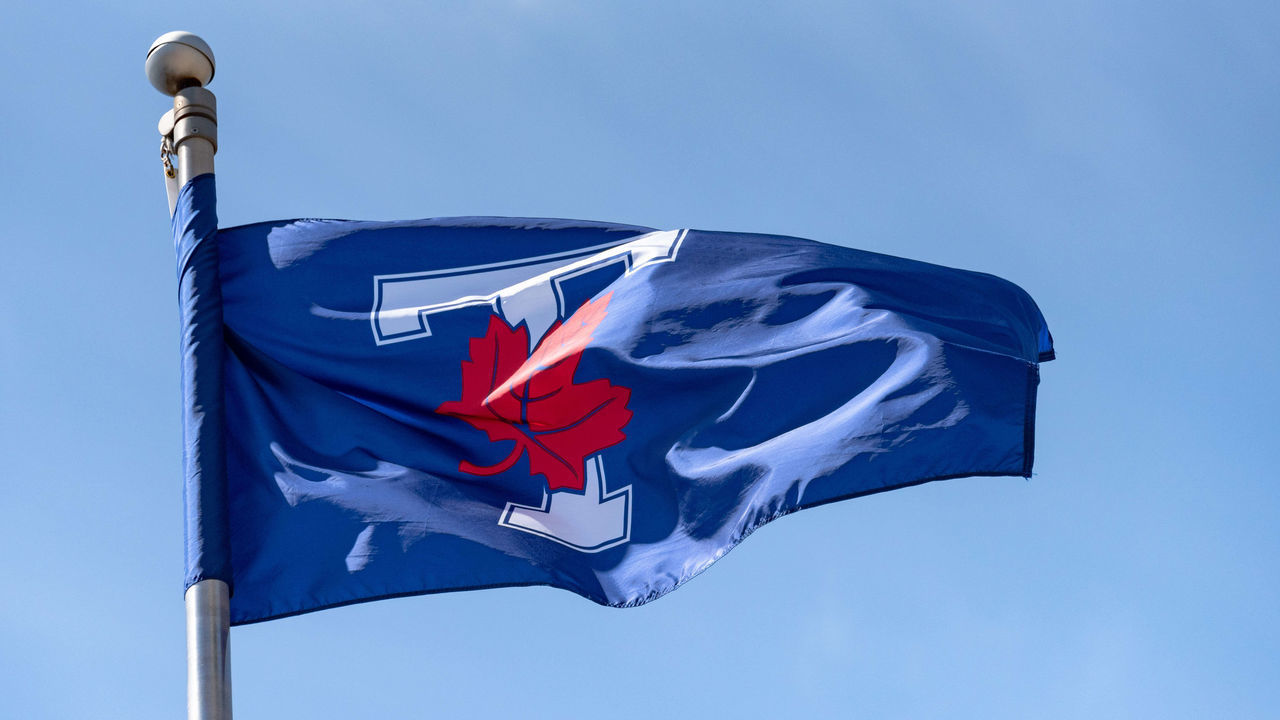 TORONTO, ONTARIO, CANADA - 2018/04/21: University of Toronto (U of T) Varsity Blues Flag waving on a blue clear sky. The Varsity Blues is a intercollegiate sports program in the Canadian city.