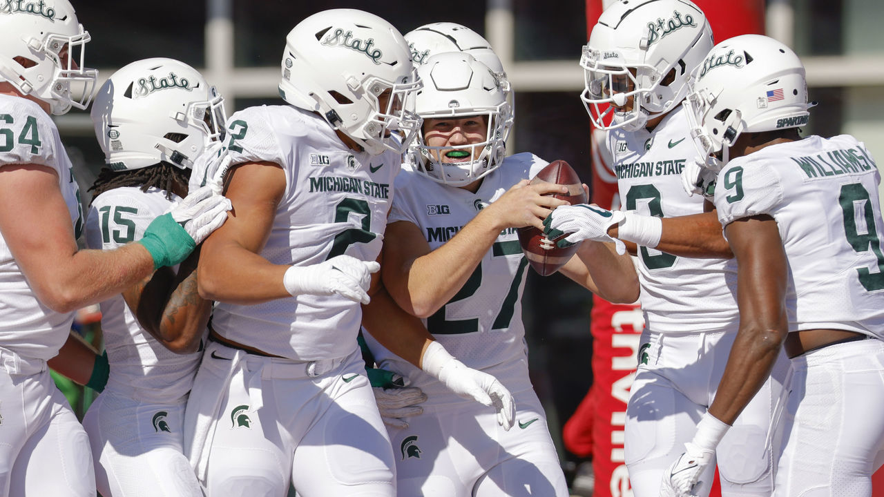 BLOOMINGTON, IN - OCTOBER 16: Members of the Michigan State Spartans defense celebrate with Cal Haladay #27 of the Michigan State Spartans after an interception returned for a touchdown against the Indiana Hoosiers at Indiana University on October 16, 2021 in Bloomington, Indiana.