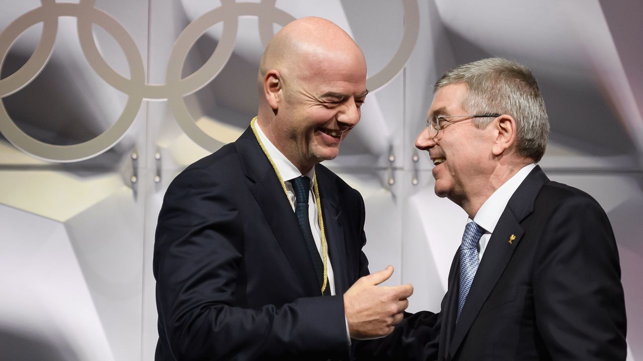 International Olympic Committee (IOC) president Thomas Bach (R) congratulates FIFA President Gianni Infantino after they have been elected as IOC members during an Olympic session in Lausanne on January 10, 2020.