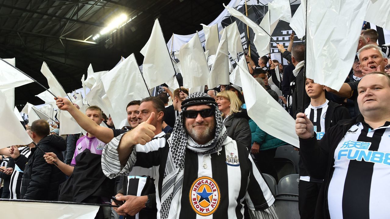 Newcastle United fans wave black and white flags and banners celebrating the club's recent take over by a Saudi-led consortium during the English Premier League football match between Newcastle United and Tottenham Hotspur at St James' Park in Newcastle-upon-Tyne, north east England on October 17, 2021. - RESTRICTED TO EDITORIAL USE. No use with unauthorized audio, video, data, fixture lists, club/league logos or 'live' services. Online in-match use limited to 120 images. An additional 40 images may be used in extra time. No video emulation. Social media in-match use limited to 120 images. An additional 40 images may be used in extra time. No use in betting publications, games or single club/league/player publications.