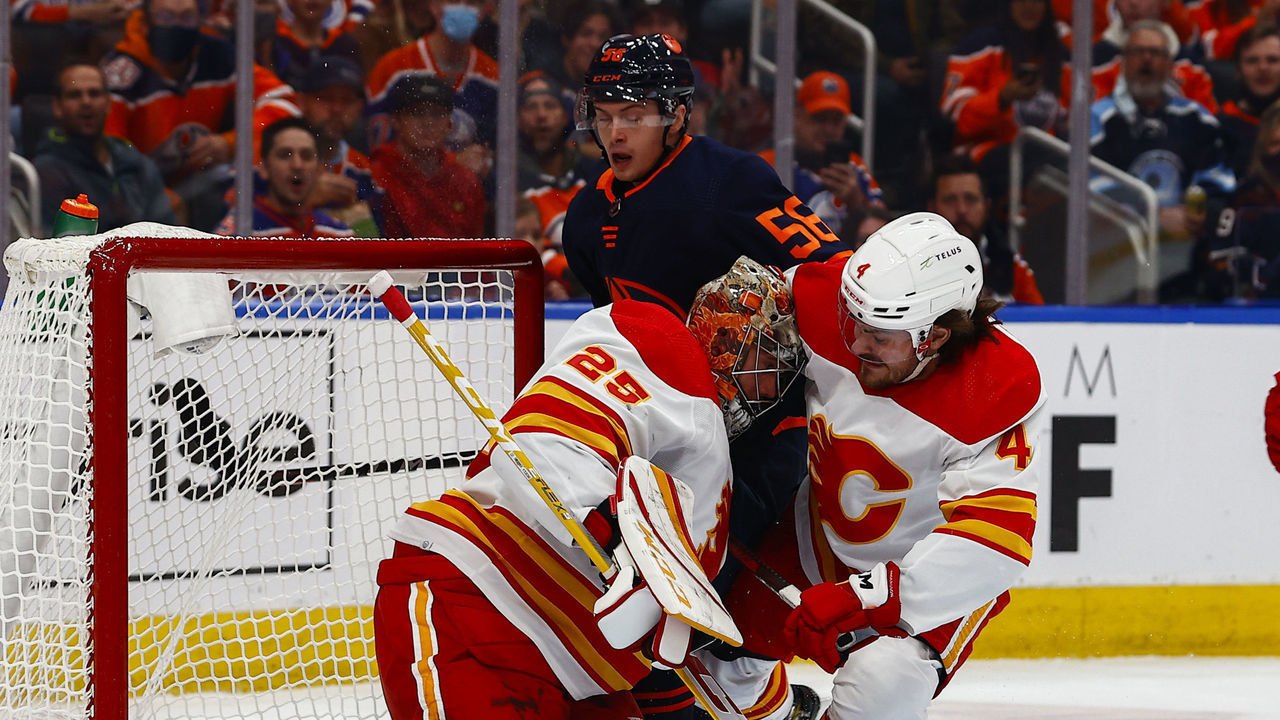 EDMONTON, AB - OCTOBER 16: Calgary Flames Goalie Jacob Markstrom (25) is hit by Edmonton Oilers Right Wing Kailer Yamamoto (56) and Calgary Flames Defenceman Rasmus Andersson (4) in the first period during the Edmonton Oilers game versus the Calgary Flames on October 16, 2021 at Rogers Place in Edmonton, AB.
