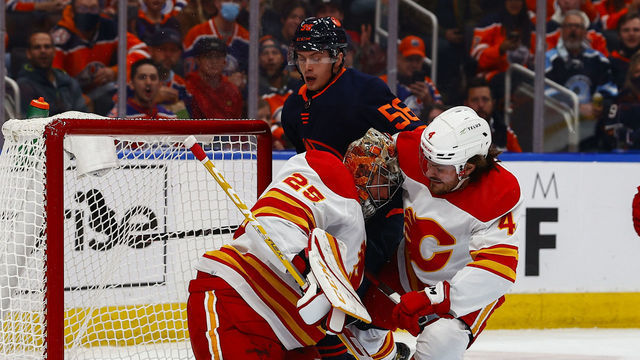EDMONTON, AB - OCTOBER 16: Calgary Flames Goalie Jacob Markstrom (25) is hit by Edmonton Oilers Right Wing Kailer Yamamoto (56) and Calgary Flames Defenceman Rasmus Andersson (4) in the first period during the Edmonton Oilers game versus the Calgary Flames on October 16, 2021 at Rogers Place in Edmonton, AB.