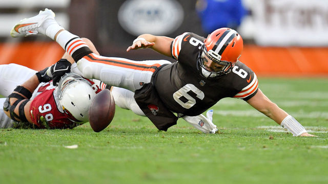 CLEVELAND, OHIO - OCTOBER 17: Baker Mayfield #6 of the Cleveland Browns fumbles the ball after a tackle from J.J. Watt #99 of the Arizona Cardinals during the third quarter at FirstEnergy Stadium on October 17, 2021 in Cleveland, Ohio.