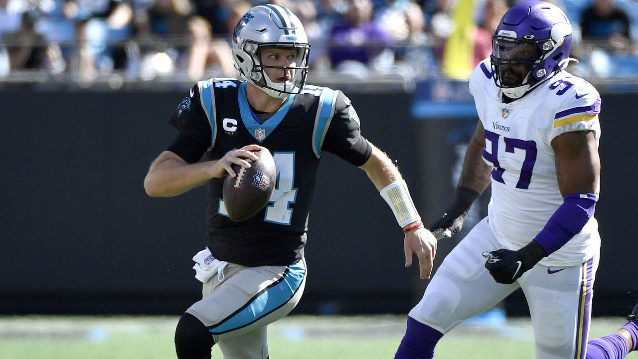 CHARLOTTE, NORTH CAROLINA - OCTOBER 17: Sam Darnold #14 of the Carolina Panthers runs out of the pocket against Everson Griffen #97 of the Minnesota Vikings during the second quarter at Bank of America Stadium on October 17, 2021 in Charlotte, North Carolina.