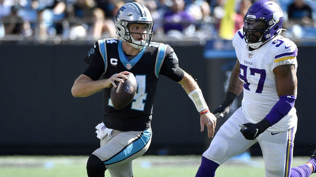 CHARLOTTE, NORTH CAROLINA - OCTOBER 17: Sam Darnold #14 of the Carolina Panthers runs out of the pocket against Everson Griffen #97 of the Minnesota Vikings during the second quarter at Bank of America Stadium on October 17, 2021 in Charlotte, North Carolina.