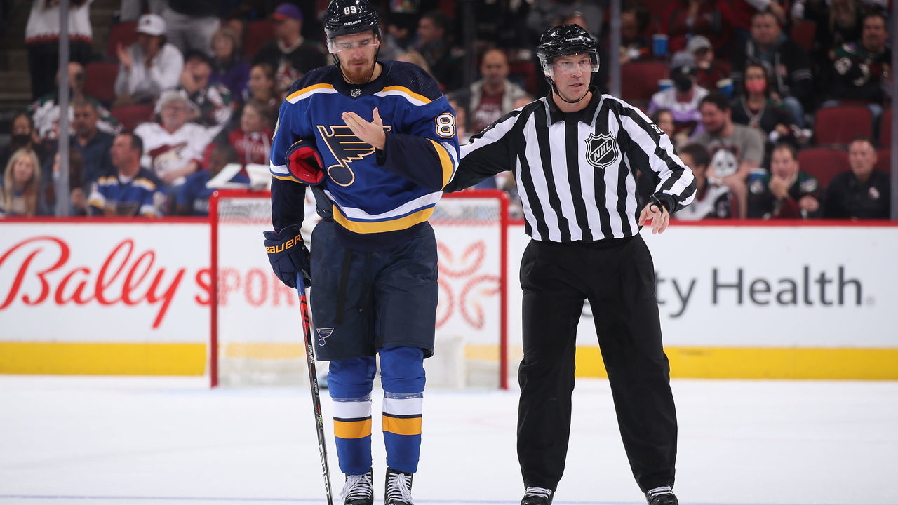 GLENDALE, ARIZONA - OCTOBER 18: Pavel Buchnevich #89 of the St. Louis Blues is escorted off the ice by linesman Mark Shewchyk #92 after a 5 minute penalty during the first period of the NHL game at Gila River Arena on October 18, 2021 in Glendale, Arizona.