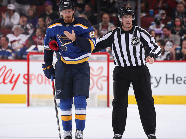 GLENDALE, ARIZONA - OCTOBER 18: Pavel Buchnevich #89 of the St. Louis Blues is escorted off the ice by linesman Mark Shewchyk #92 after a 5 minute penalty during the first period of the NHL game at Gila River Arena on October 18, 2021 in Glendale, Arizona.