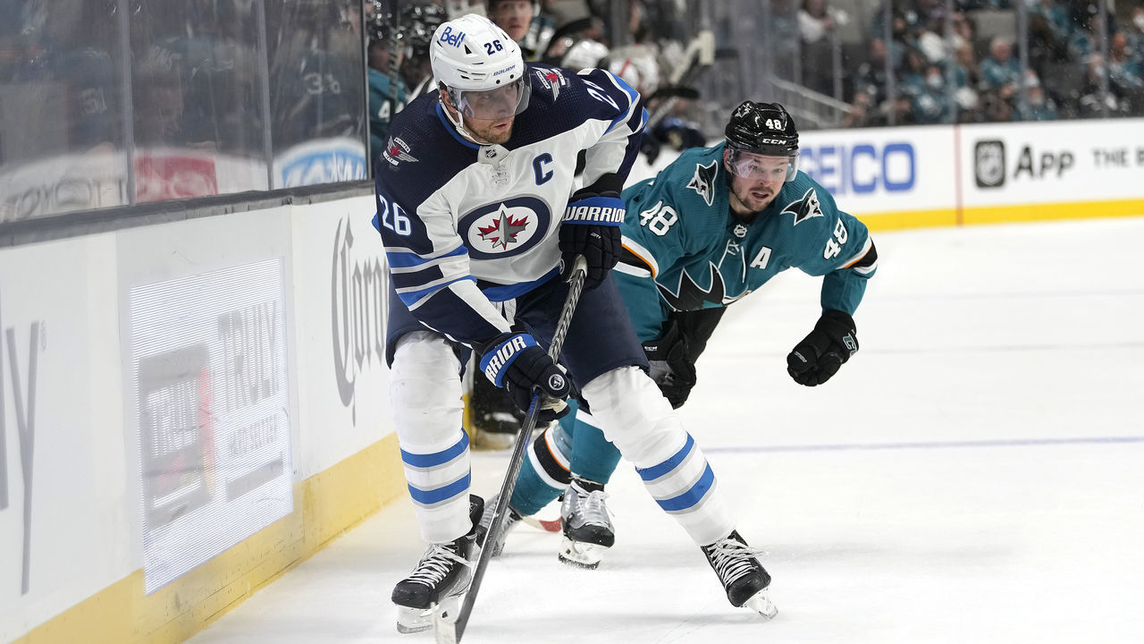 SAN JOSE, CALIFORNIA - OCTOBER 16: Blake Wheeler #26 of the Winnipeg Jets skates with the puck against Tomas Hertl #48 of the San Jose Sharks during the first period at SAP Center on October 16, 2021 in San Jose, California.