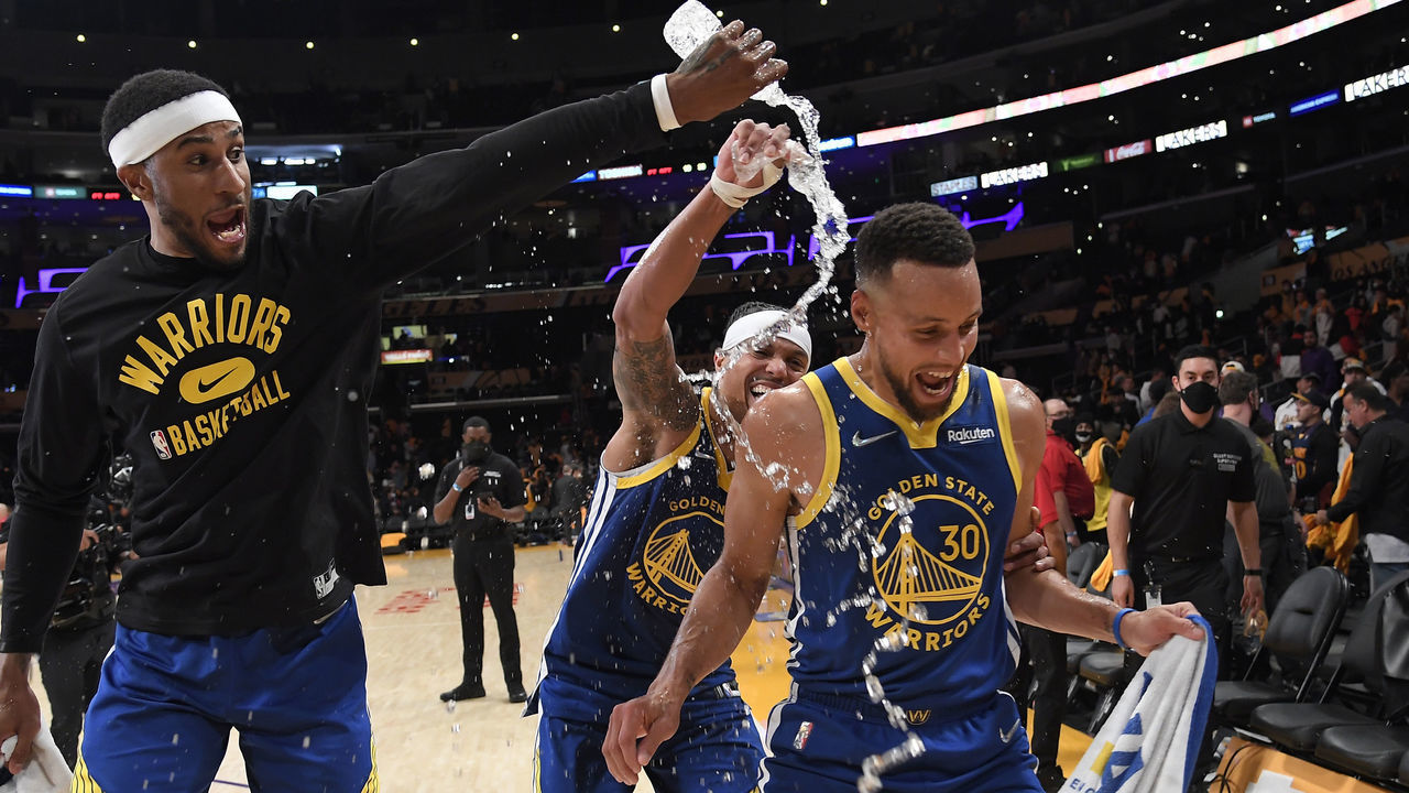 LOS ANGELES, CA - OCTOBER 19: Stephen Curry #30 of the Golden State Warriors is showered with water by his teammates Gary Payton II #0 and Damion Lee #1 as they celebrate after defeating the Los Angeles Lakers 121-114 at Staples Center on October 19, 2021 in Los Angeles, California. NOTE TO USER: User expressly acknowledges and agrees that, by downloading and/or using this Photograph, user is consenting to the terms and conditions of the Getty Images License Agreement.