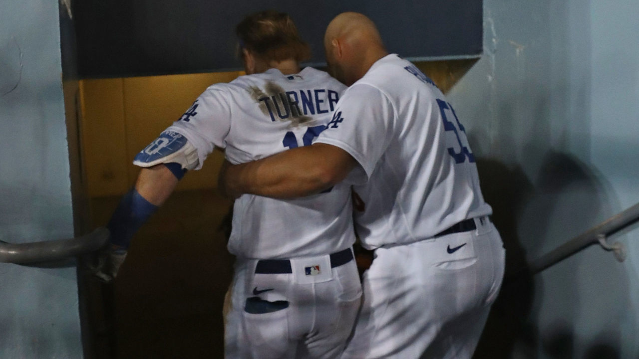 LOS ANGELES, CALIFORNIA - OCTOBER 20: Albert Pujols #55 of the Los Angeles Dodgers helps Justin Turner #10 out of the dugout after suffering an injury during the seventh inning of Game Four of the National League Championship Series against the Atlanta Braves at Dodger Stadium on October 20, 2021 in Los Angeles, California.