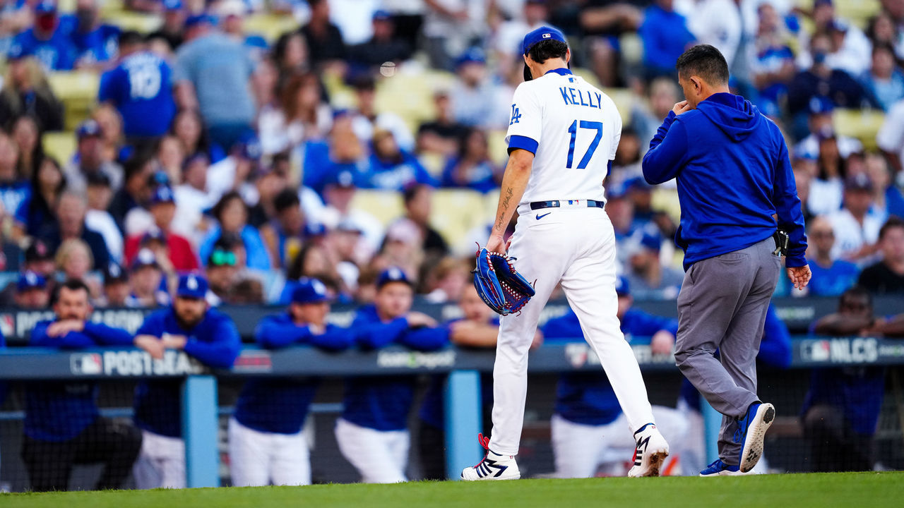 LOS ANGELES, CA - OCTOBER 21: Joe Kelly #17 of the Los Angeles Dodgers walks to the dugout with Head Athletic Trainer Neil Rampe in the first inning during Game 5 of the NLCS between the Atlanta Braves and the Los Angeles Dodgers at Dodgers Stadium on Thursday, October 21, 2021 in Los Angeles, California.