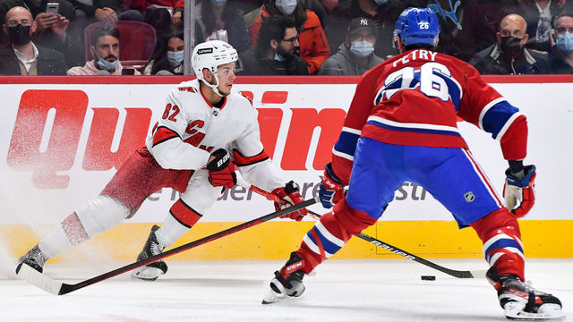 MONTREAL, QC - OCTOBER 21: Jesperi Kotkaniemi #82 of the Carolina Hurricanes skates with the puck under pressure from Jeff Petry #26 of the Montreal Canadiens in the NHL game at the Bell Centre on October 21, 2021 in Montreal, Quebec, Canada.