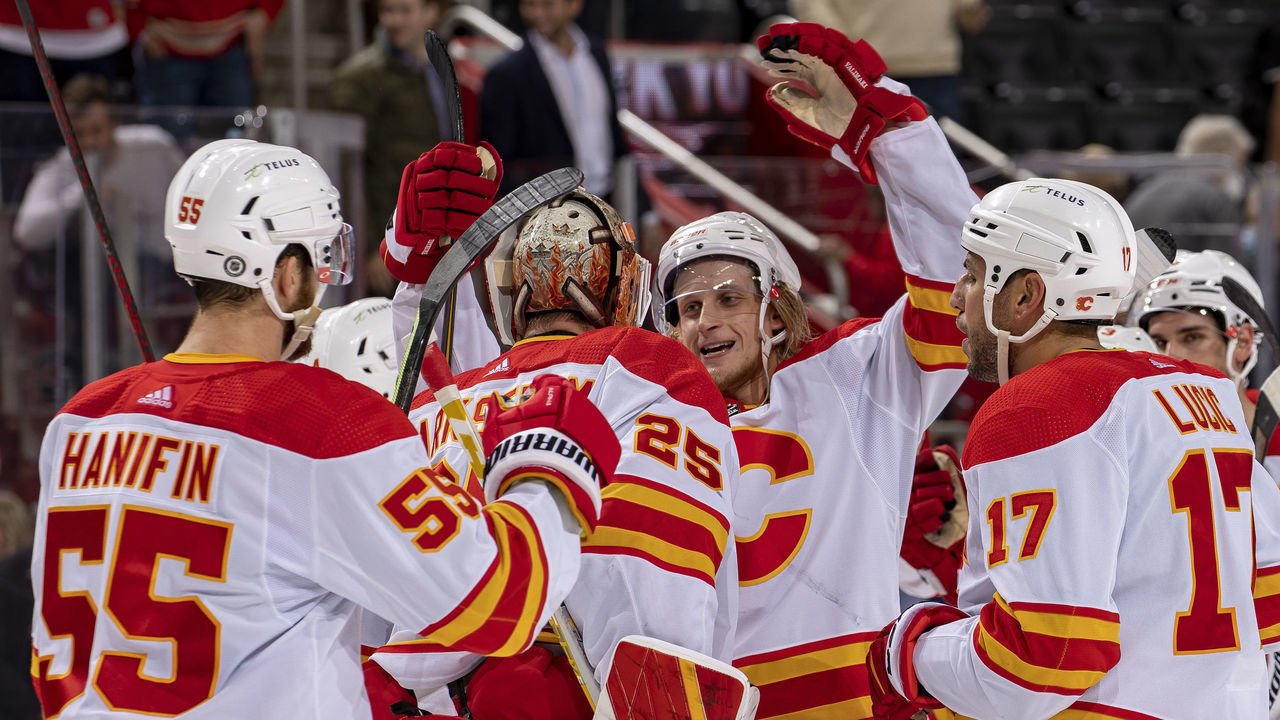 DETROIT, MI - OCTOBER 21: Teammates congratulate Jacob Markstrom #25 of the Calgary Flames after getting a shutout in an NHL game against the Detroit Red Wings at Little Caesars Arena on October 21, 2021 in Detroit, Michigan. Calgary defeated Detroit 3-0.