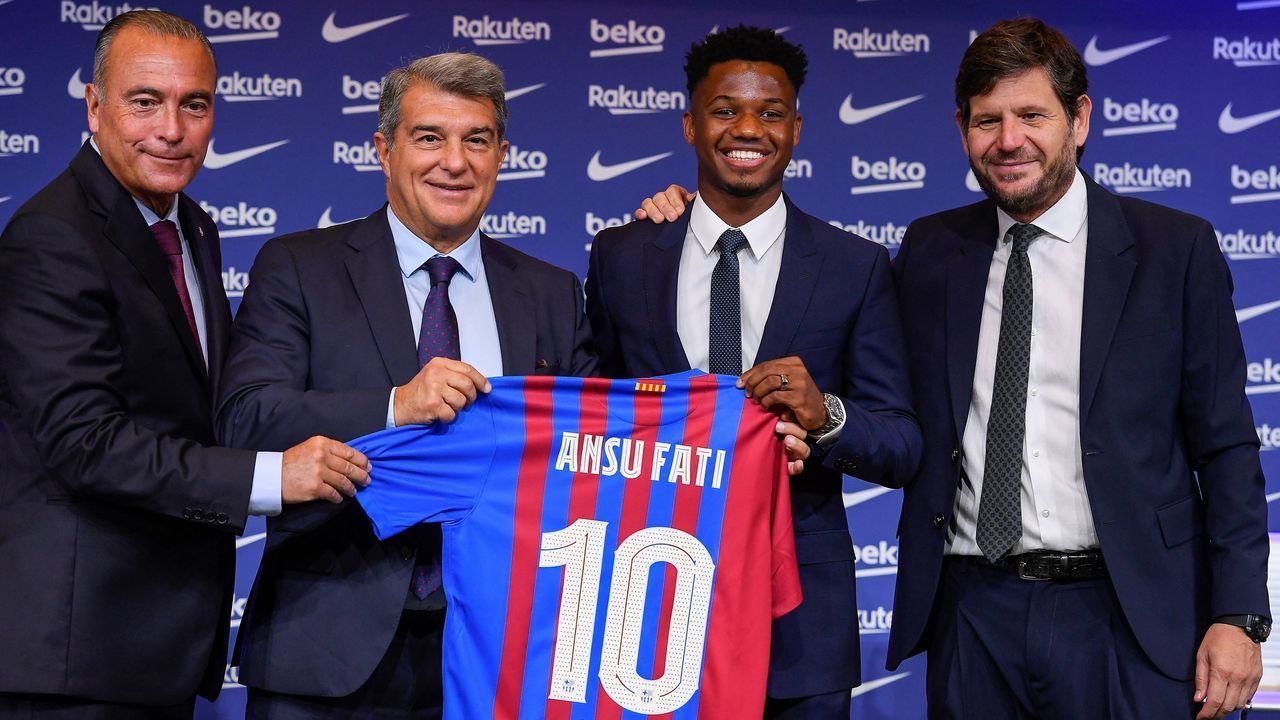Barcelona's Spanish midfielder Ansu Fati (2nd-R) poses for pictures holding his jersey with President of FC Barcelona Joan Laporta (2nd-L), FC Barcelona's first vice president Rafael Yuste (L) and FC Barcelona's sports director Mateu Alemany (R) during his contract renewal signing ceremony in Barcelona, on October 21, 2021. - Ansu Fati has extended his contract with Barcelona until 2027, the club announced on October 20, shortly after their 1-0 victory over Dynamo Kiev in the Champions League.