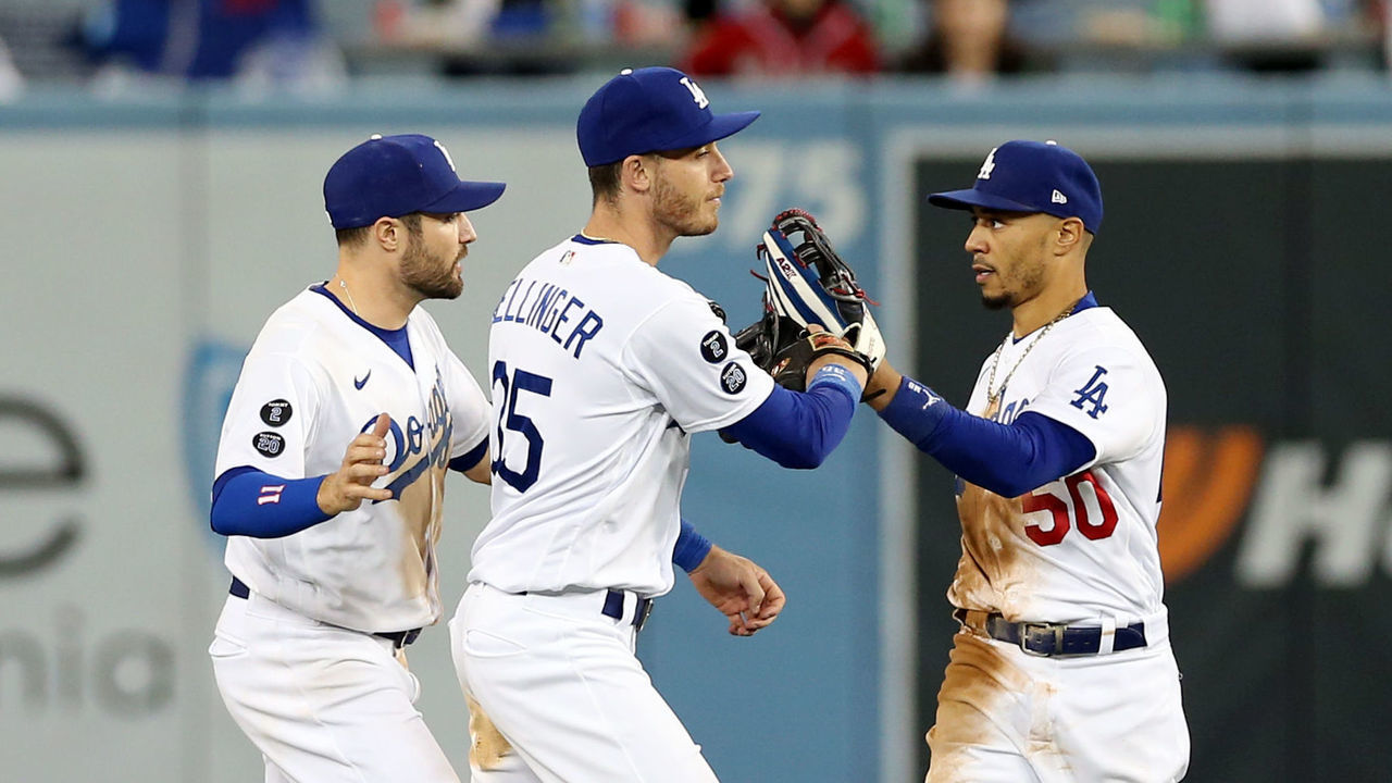 LOS ANGELES, CA - OCTOBER 21: AJ Pollock #11, Cody Bellinger #35 and Mookie Betts #50 of the Los Angeles Dodgers celebrate after the Dodgers defeated the Atlanta Braves in Game 5 of the NLCS at Dodgers Stadium on Thursday, October 21, 2021 in Los Angeles, California.