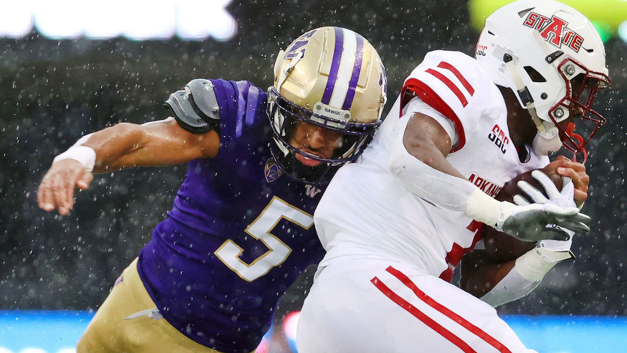 SEATTLE, WASHINGTON - SEPTEMBER 18: Johnnie Lang Jr. #2 of the Arkansas State Red Wolves is tackled by Jackson Sirmon #43 and Alex Cook #5 of the Washington Huskies during the second quarter at Husky Stadium on September 18, 2021 in Seattle, Washington.