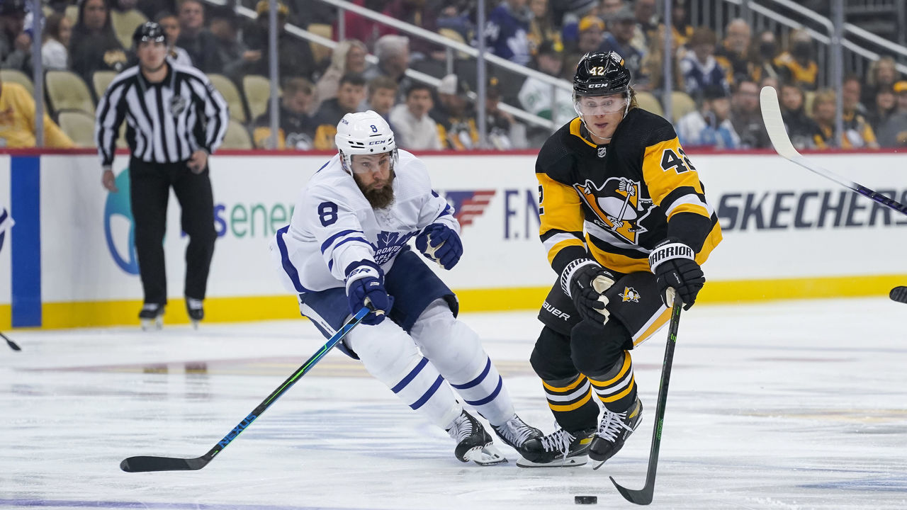 PITTSBURGH, PA - OCTOBER 23: Pittsburgh Penguins Right Wing Kasperi Kapanen (42) skates with the puck as Toronto Maple Leafs Defenceman Jake Muzzin (8) defends during the first period in the NHL game between the Pittsburgh Penguins and the Toronto Maple Leafs on October 23, 2021, at PPG Paints Arena in Pittsburgh, PA.