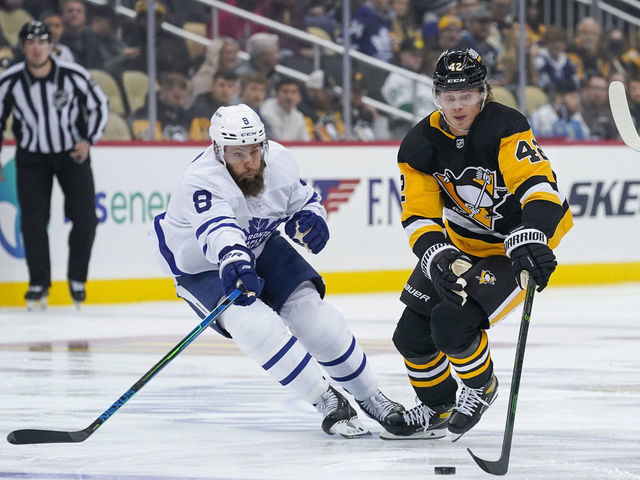 PITTSBURGH, PA - OCTOBER 23: Pittsburgh Penguins Right Wing Kasperi Kapanen (42) skates with the puck as Toronto Maple Leafs Defenceman Jake Muzzin (8) defends during the first period in the NHL game between the Pittsburgh Penguins and the Toronto Maple Leafs on October 23, 2021, at PPG Paints Arena in Pittsburgh, PA.