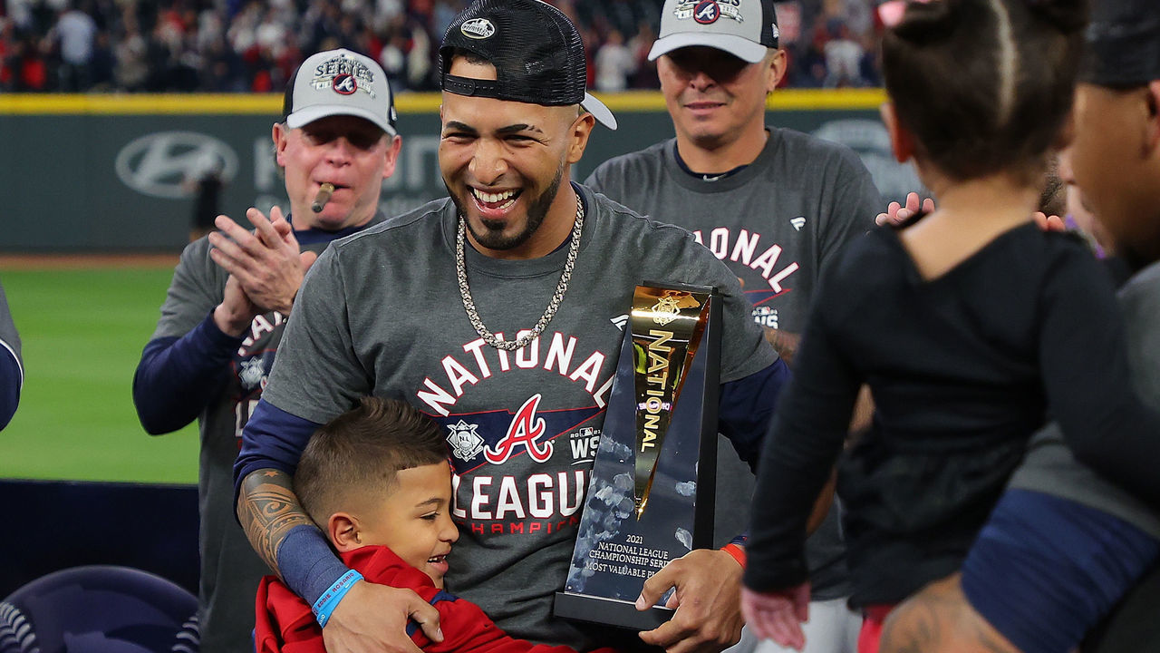 ATLANTA, GEORGIA - OCTOBER 23: Eddie Rosario #8 of the Atlanta Braves is hugged by his son after being named the Most Valuable Player of the National League Championship Series after defeating the Los Angeles Dodgers at Truist Park on October 23, 2021 in Atlanta, Georgia. The Braves defeated the Dodgers 4-2 to advance to the 2021 World Series.