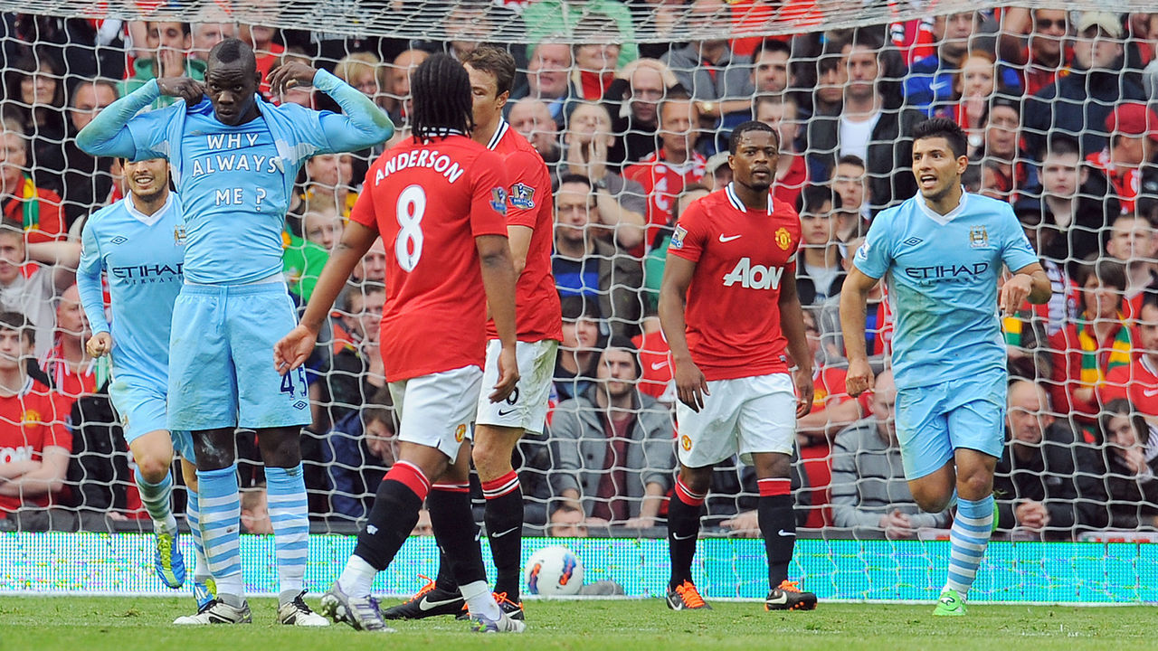 Manchester City's Italian striker Mario Balotelli (L) celebrates scoring the opening goal of the English Premier League football match between Manchester United and Manchester City at Old Trafford in Manchester, north-west England on October 23, 2011. AFP PHOTO/ANDREW YATES RESTRICTED TO EDITORIAL USE. No use with unauthorized audio, video, data, fixture lists, club/league logos or “live” services. Online in-match use limited to 45 images, no video emulation. No use in betting, games or single club/league/player publications