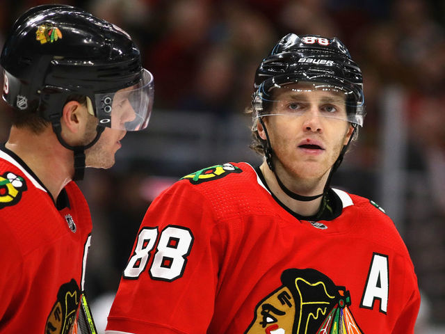 CHICAGO, ILLINOIS - DECEMBER 27: Jonathan Toews #19 of the Chicago Blackhawks talks with Patrick Kane #88 before a face-off against the New York Islanders at the United Center on December 27, 2019 in Chicago, Illinois. The Blackhawks defeated the Islanders 5-2.