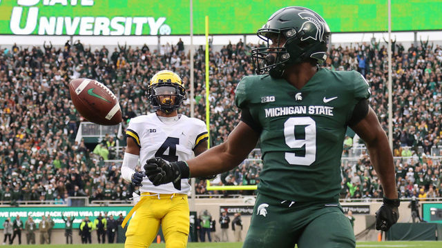 EAST LANSING, MICHIGAN - OCTOBER 30: Kenneth Walker III #9 of the Michigan State Spartans scores a first half touchdown in front of Vincent Gray #4 of the Michigan Wolverines at Spartan Stadium on October 30, 2021 in East Lansing, Michigan.