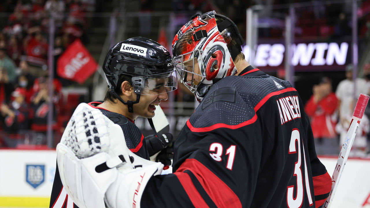 RALEIGH, NC - OCTOBER 31: Goaltender Frederik Andersen #31 of the Carolina Hurricanes is congratulated on his 2-1 victory by teammate Seth Jarvis #24 who records his first NHL point following an NHL game against the Arizona Coyotes on October 31, 2021 at PNC Arena in Raleigh, North Carolina.