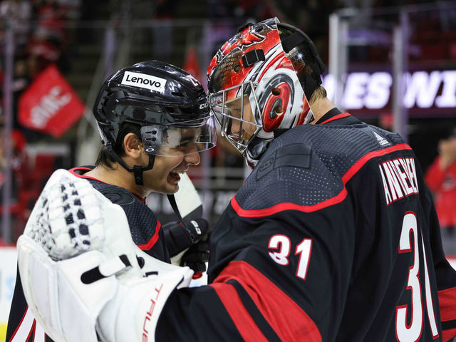 RALEIGH, NC - OCTOBER 31: Goaltender Frederik Andersen #31 of the Carolina Hurricanes is congratulated on his 2-1 victory by teammate Seth Jarvis #24 who records his first NHL point following an NHL game against the Arizona Coyotes on October 31, 2021 at PNC Arena in Raleigh, North Carolina.