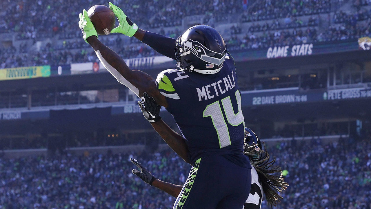 SEATTLE, WASHINGTON - OCTOBER 31: DK Metcalf #14 of the Seattle Seahawks catches the ball over Shaquill Griffin #26 of the Jacksonville Jaguars for a touchdown during the second quarter at Lumen Field on October 31, 2021 in Seattle, Washington.