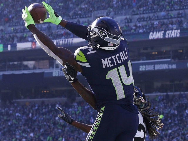 SEATTLE, WASHINGTON - OCTOBER 31: DK Metcalf #14 of the Seattle Seahawks catches the ball over Shaquill Griffin #26 of the Jacksonville Jaguars for a touchdown during the second quarter at Lumen Field on October 31, 2021 in Seattle, Washington.