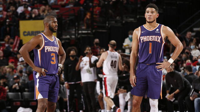 PORTLAND, OR - OCTOBER 23: Chris Paul #3 and Devin Booker #1 of the Phoenix Suns look on during the game against the Portland Trail Blazers on October 23, 2021 at the Moda Center Arena in Portland, Oregon. Mandatory Copyright Notice: Copyright 2021 NBAE