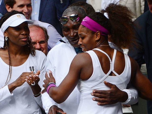 US player Serena Williams (R) climbs up into the Royal Box to embrace her father Richard and sister Venus Williams (L) after her women's singles final victory over Poland's Agnieszka Radwanska on day 12 of the 2012 Wimbledon Championships tennis tournament at the All England Tennis Club in Wimbledon, southwest London, on July 7, 2012. Serena Williams won the match 6-1, 5-7, 6-2. AFP PHOTO/ LEON NEAL RESTRICTED TO EDITORIAL USE