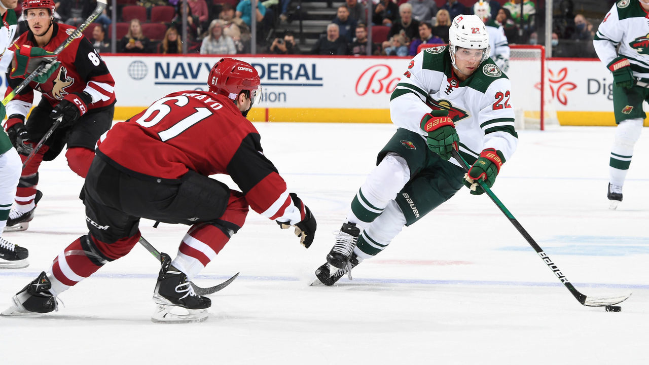 GLENDALE, ARIZONA - NOVEMBER 10: Kevin Fiala #22 of the Minnesota Wild skates with the puck while being defended by Dysin Mayo #61 of the Arizona Coyotes during the first period at Gila River Arena on November 10, 2021 in Glendale, Arizona.