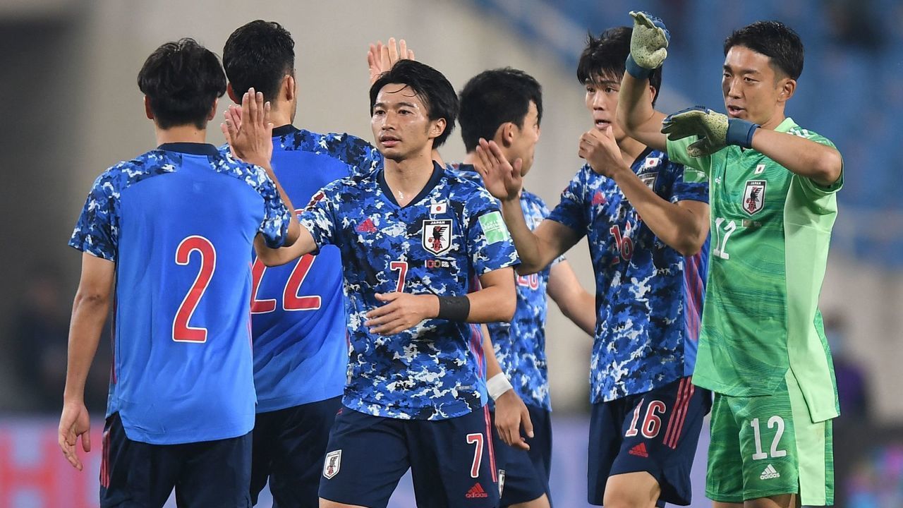 Japan's players celebrate after winning their FIFA World Cup Qatar 2022 qualifying round Group B football match against Vietnam at My Dinh National Stadium in Hanoi on November 11, 2021.