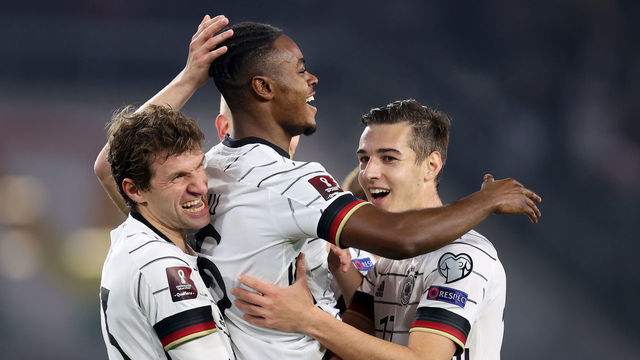 WOLFSBURG, GERMANY - NOVEMBER 11: Ridle Baku (C) of Germany celebrate with Thomas Müller (L) and Florian Neuhaus after he scores the 7th goal during the 2022 FIFA World Cup Qualifier match between Germany and Liechtenstein at Volkswagen Arena on November 11, 2021 in Wolfsburg, Germany.