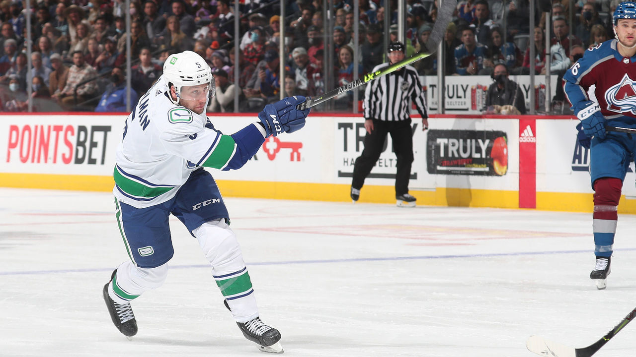 DENVER, COLORADO - NOVEMBER 11: Tucker Poolman #5 of the Vancouver Canucks skates shoots against the Colorado Avalanche at Ball Arena on November 11, 2021 in Denver, Colorado.