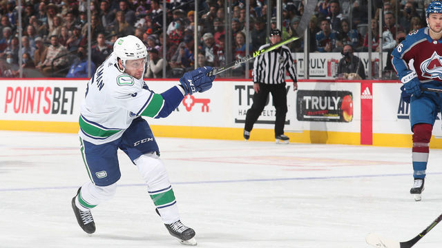 DENVER, COLORADO - NOVEMBER 11: Tucker Poolman #5 of the Vancouver Canucks skates shoots against the Colorado Avalanche at Ball Arena on November 11, 2021 in Denver, Colorado.