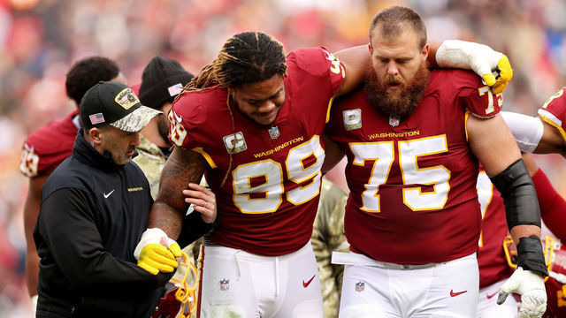 LANDOVER, MARYLAND - NOVEMBER 14: Chase Young #99 of the Washington Football Team is help off the field after an injury during the first half against the Tampa Bay Buccaneers at FedExField on November 14, 2021 in Landover, Maryland.