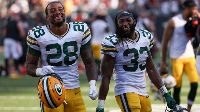 CINCINNATI, OHIO - OCTOBER 10: AJ Dillon #28 and Aaron Jones #33 of the Green Bay Packers walk off the field after beating the Cincinnati Bengals 25-22 in overtime at Paul Brown Stadium on October 10, 2021 in Cincinnati, Ohio.