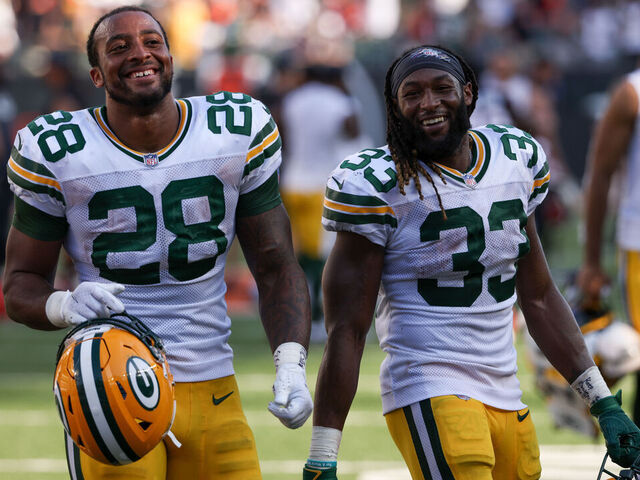 CINCINNATI, OHIO - OCTOBER 10: AJ Dillon #28 and Aaron Jones #33 of the Green Bay Packers walk off the field after beating the Cincinnati Bengals 25-22 in overtime at Paul Brown Stadium on October 10, 2021 in Cincinnati, Ohio.