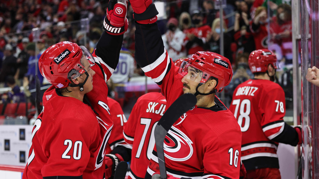 RALEIGH, NC - NOVEMBER 13: Sebastian Aho #20 of the Carolina Hurricanes and teammate Vincent Trocheck #16 celebrate a 3-2 victory over the St. Louis Blues following an NHL game on November 13, 2021 at PNC Arena in Raleigh, North Carolina.