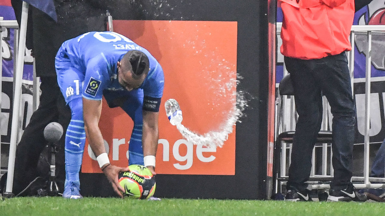 TOPSHOT - Marseille's French midfielder Dimitri Payet (L) receives a bottle of water from the grandstand during the French L1 football match between Olympique Lyonnais and Olympique de Marseille at the Groupama stadium in Decines-Charpieu, near Lyon, south-eastern France, on November 21, 2021.