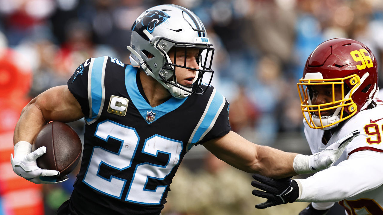CHARLOTTE, NORTH CAROLINA - NOVEMBER 21: Christian McCaffrey #22 of the Carolina Panthers carries the ball against the defense of the Washington Football Team in the first quarter of the game at Bank of America Stadium on November 21, 2021 in Charlotte, North Carolina.