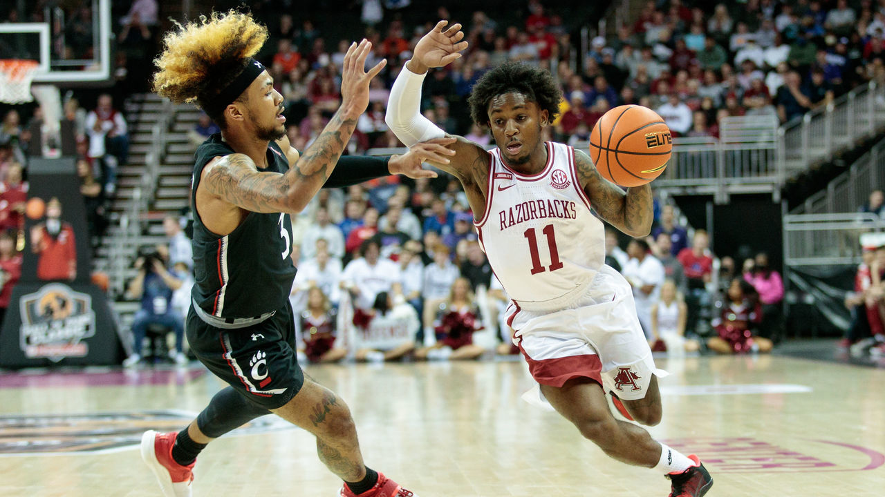 KANSAS CITY, MO - NOVEMBER 23: Arkansas Razorbacks guard Chris Lykes (11) drives to the basket around Cincinnati Bearcats guard Mike Saunders (3) on November 23rd, 2021 at the T Mobile Center in Kansas City, Missouri.