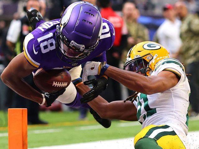 MINNEAPOLIS, MINNESOTA - NOVEMBER 21: Justin Jefferson #18 of the Minnesota Vikings dives into the end zone for a touchdown as Eric Stokes #21 of the Green Bay Packers tries to tackle in the fourth quarter at U.S. Bank Stadium on November 21, 2021 in Minneapolis, Minnesota.