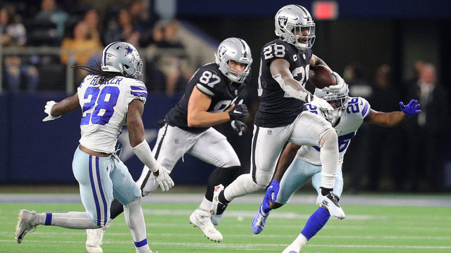 ARLINGTON, TEXAS - NOVEMBER 25: Josh Jacobs #28 of the Las Vegas Raiders makes a carry during overtime of the NFL game between Las Vegas Raiders and Dallas Cowboys at AT&T Stadium on November 25, 2021 in Arlington, Texas.