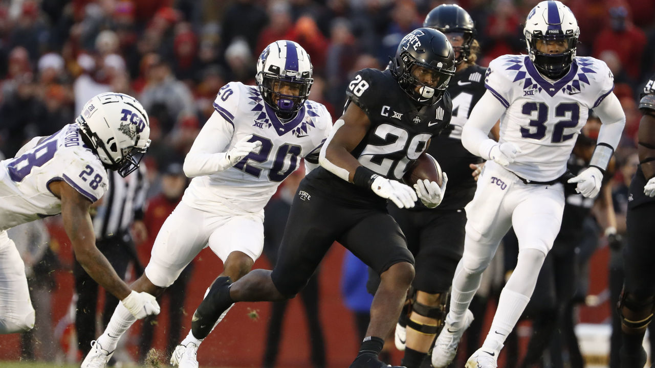 AMES, IA - NOVEMBER 26: Running back Breece Hall #28 of the Iowa State Cyclones drives the ball for a touchdown past safety Nook Bradford #28, safety La'Kendrick Van Zandt #20, and defensive end Ochaun Mathis #32 of the TCU Horned Frogs in the first half of play at Jack Trice Stadium on November 26, 2021 in Ames, Iowa.
