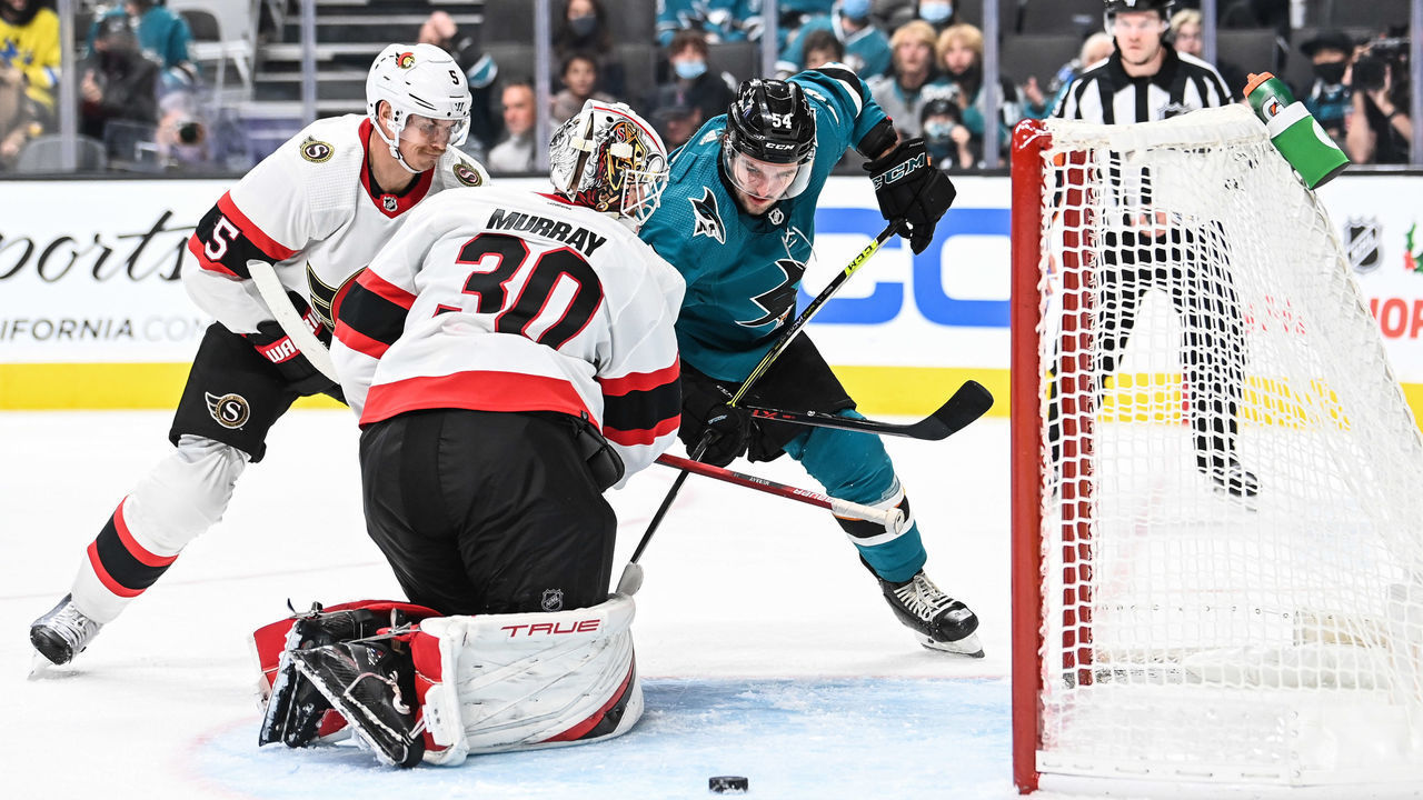 SAN JOSE, CA - NOVEMBER 24: Scott Reedy #54 of the San Jose Sharks crashes the net against Matt Murray #30 of the Ottawa Senators in a regular season game at SAP Center on November 24, 2021 in San Jose, California.