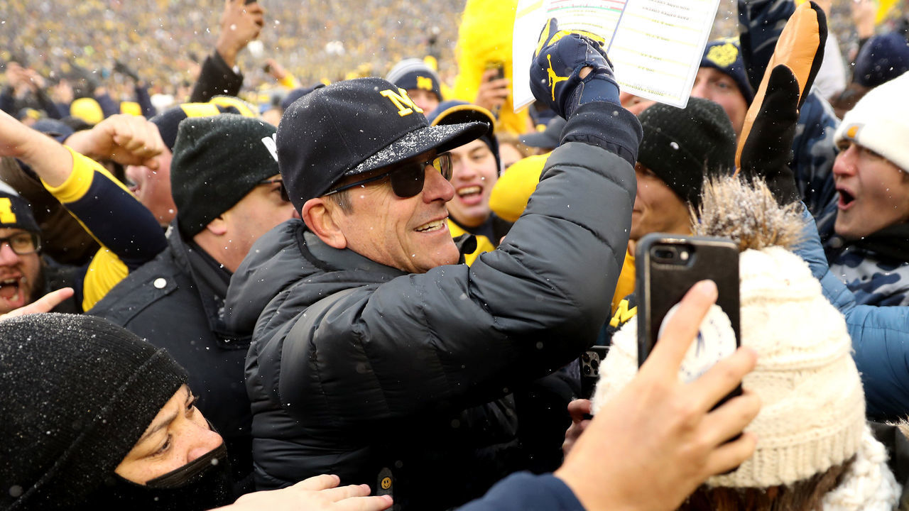 ANN ARBOR, MICHIGAN - NOVEMBER 27: Head Coach Jim Harbaugh of the Michigan Wolverines celebrates with fans after defeating the Ohio State Buckeyes at Michigan Stadium on November 27, 2021 in Ann Arbor, Michigan.