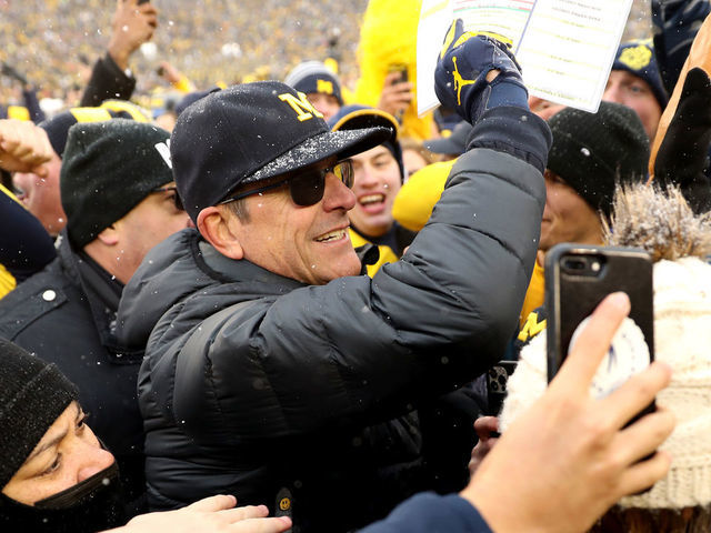 ANN ARBOR, MICHIGAN - NOVEMBER 27: Head Coach Jim Harbaugh of the Michigan Wolverines celebrates with fans after defeating the Ohio State Buckeyes at Michigan Stadium on November 27, 2021 in Ann Arbor, Michigan.
